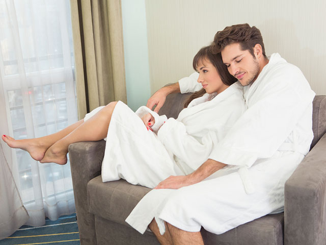 Young couple in bathrobes relaxing together