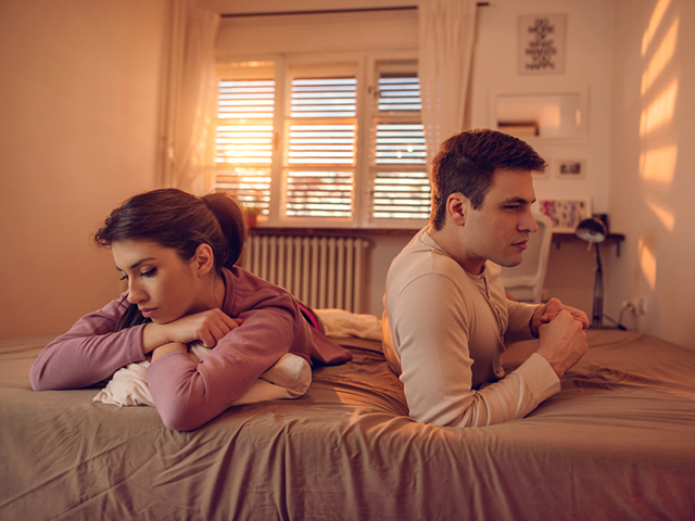 Young couple with relationship difficulties lying on the bed.